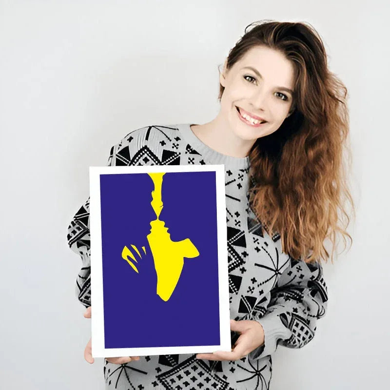 Woman holding a framed artwork with a yellow abstract figure on a blue background