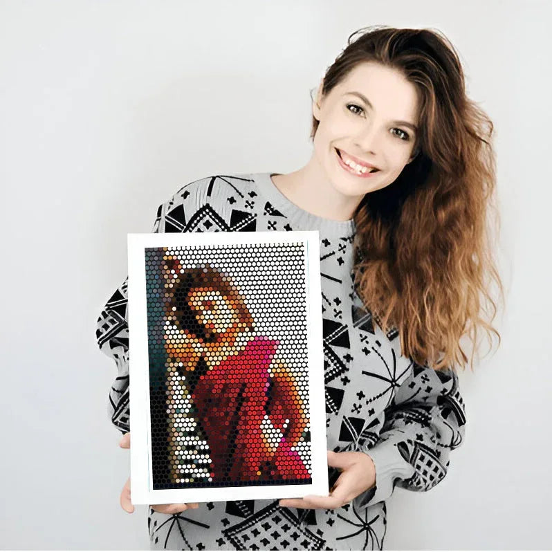 Woman holding a framed mosaic art piece against a white background