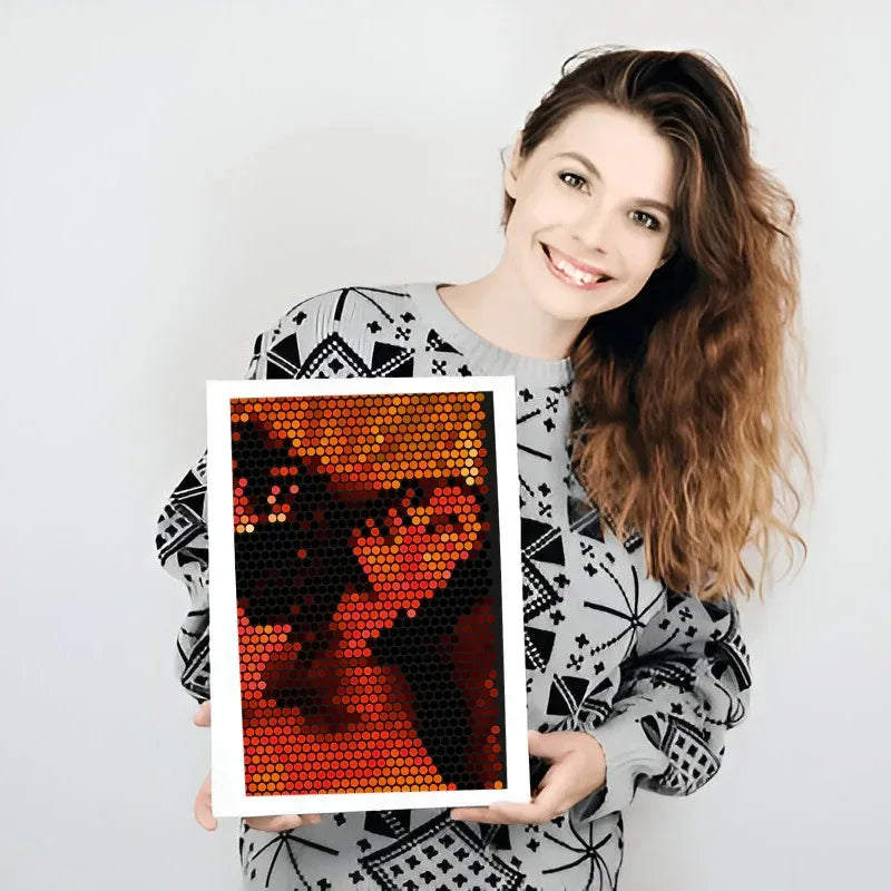 Woman holding a framed artwork with a geometric design on a plain background