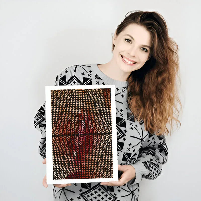 Woman holding a framed artwork with geometric pattern on a plain background