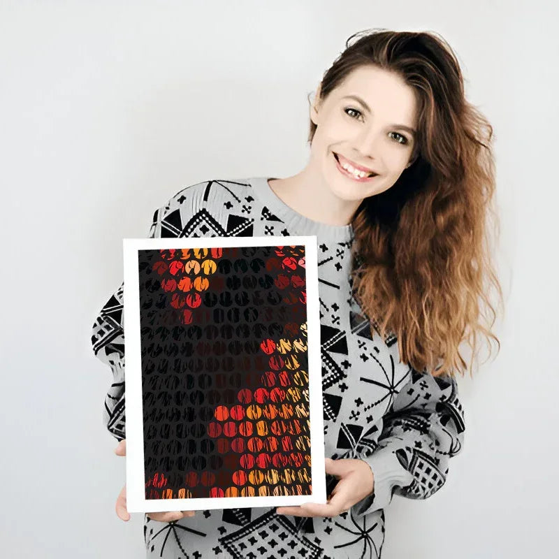 Woman holding a framed artwork with abstract patterns on a plain background