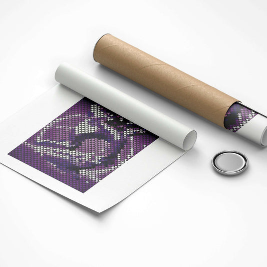 Unrolled cross-stitch pattern with a cardboard tube and metal button on a white background