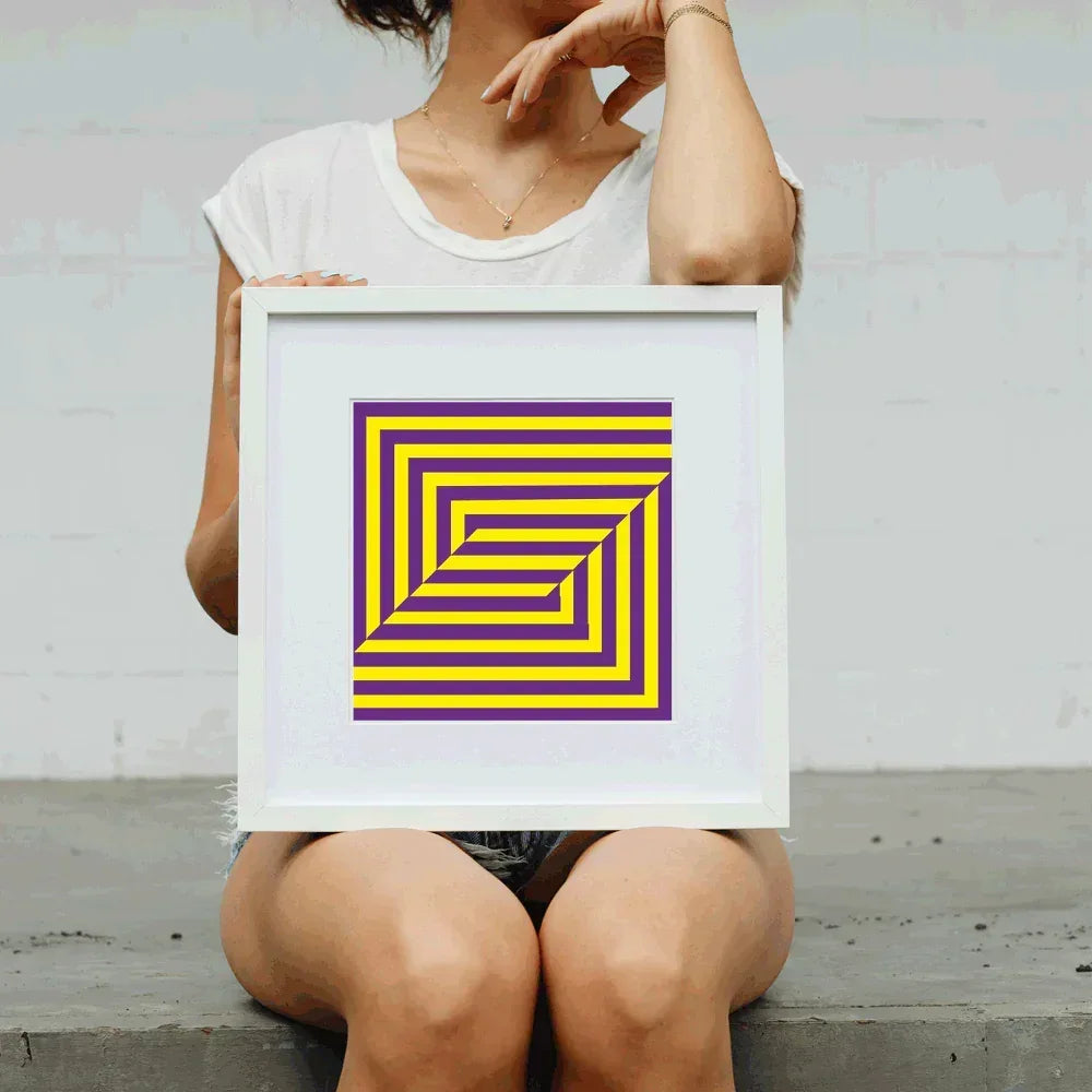 Person holding a framed artwork with a geometric design