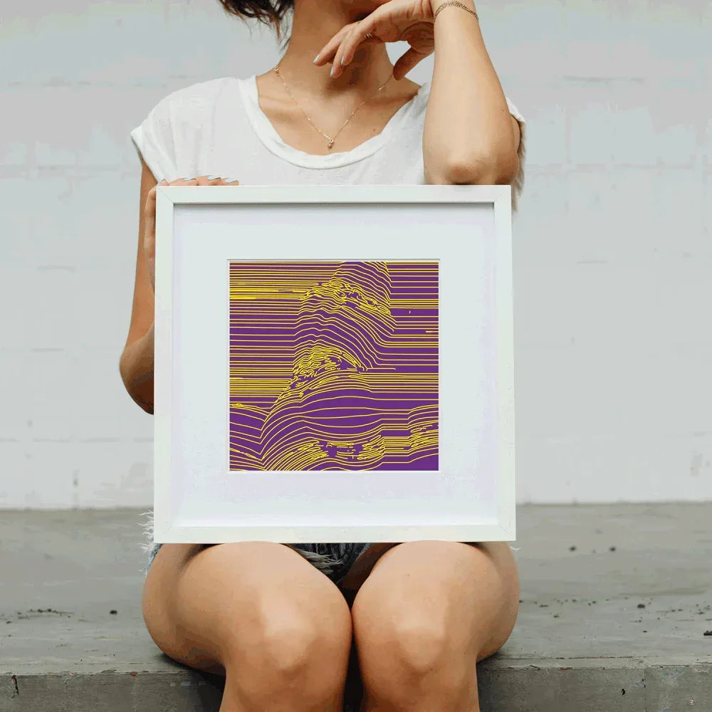 Person holding a framed abstract artwork with wavy lines in purple and yellow.