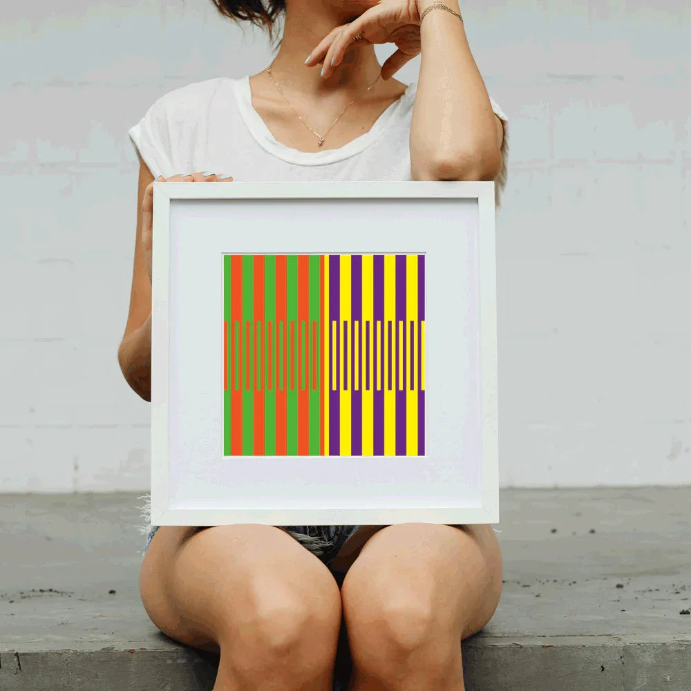 Person holding a framed colorful geometric art print against a plain background