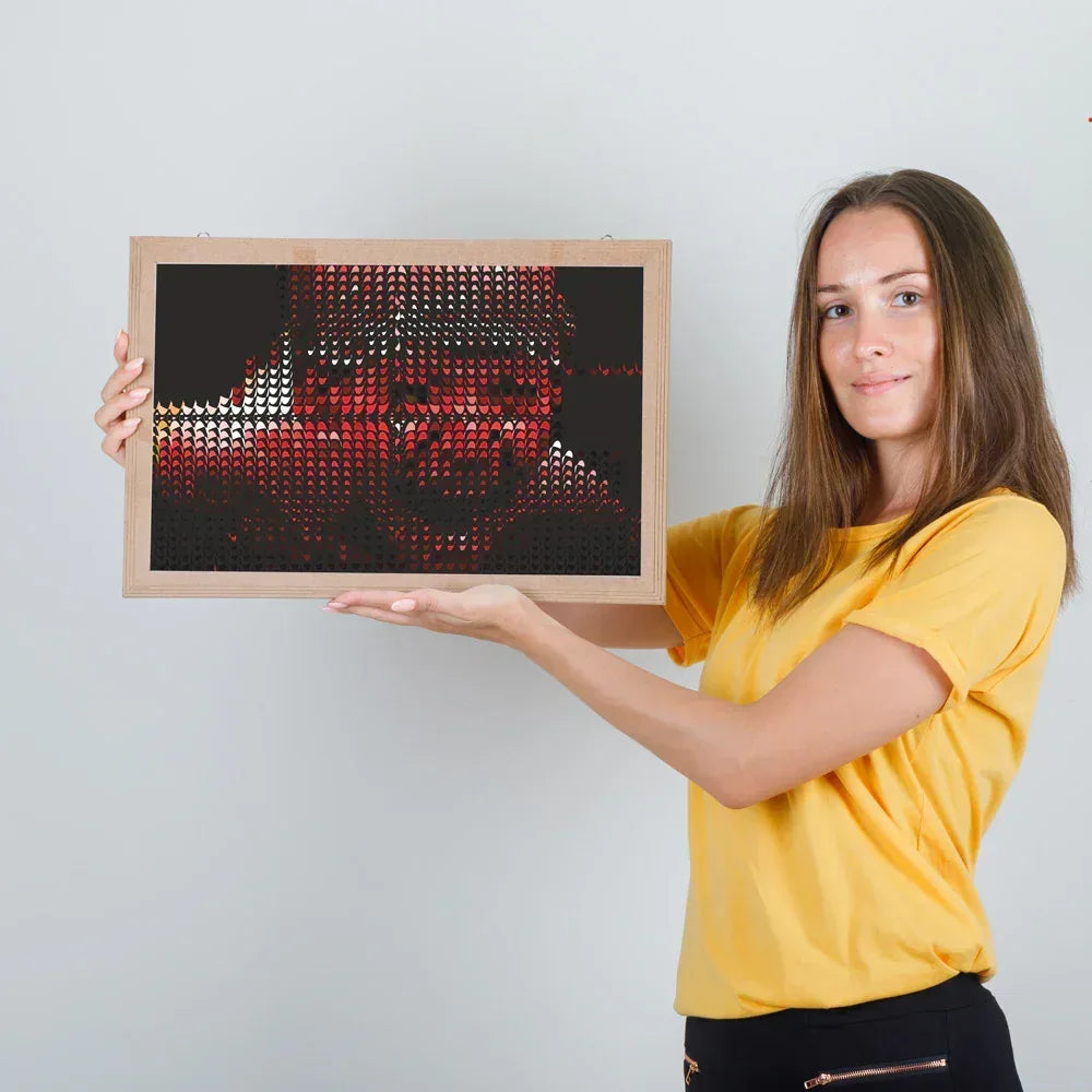 Woman holding a framed artwork with a geometric design on a plain background