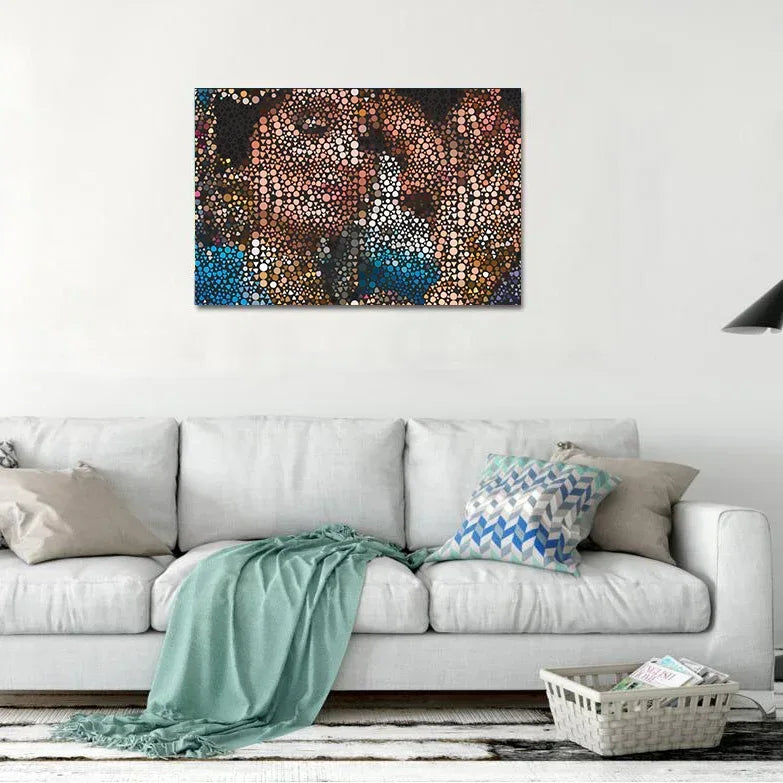 Abstract painting on a wall above a white sofa with decorative pillows and a blanket.
