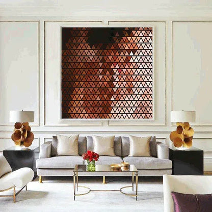 Modern living room with a geometric art piece on the wall, gray sofa, and decorative elements.