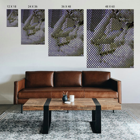 Brown leather sofa in a living room with coffee table and wall art displaying size options.