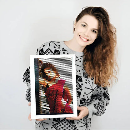 Woman holding a framed mosaic art piece against a white background