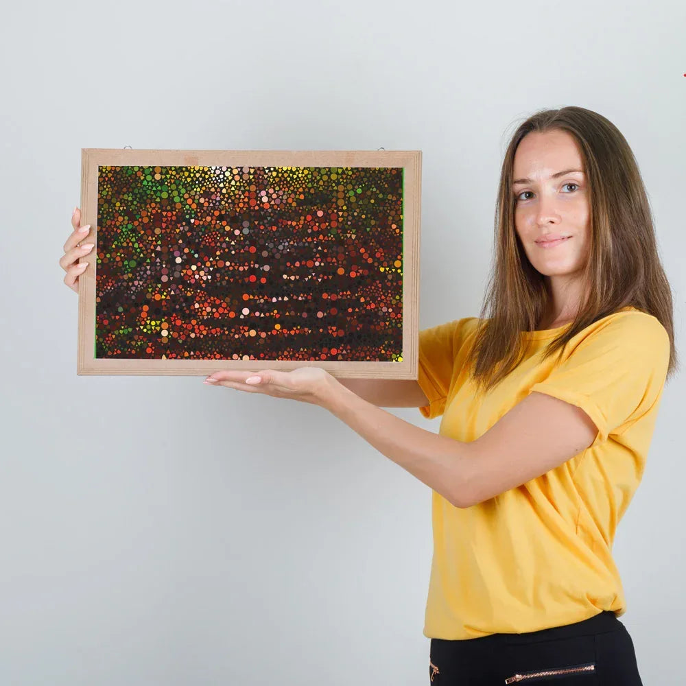 Woman holding a framed abstract art piece against a plain background