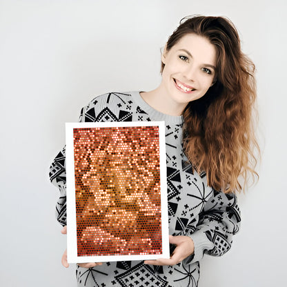 Woman holding a framed sequin art piece against a plain background