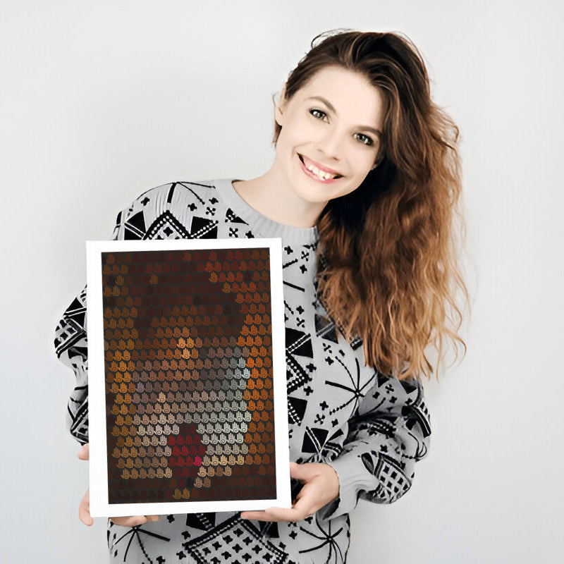 Woman holding a framed mosaic art piece against a plain background
