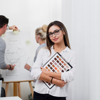 Woman holding a color swatch book with colleagues in the background