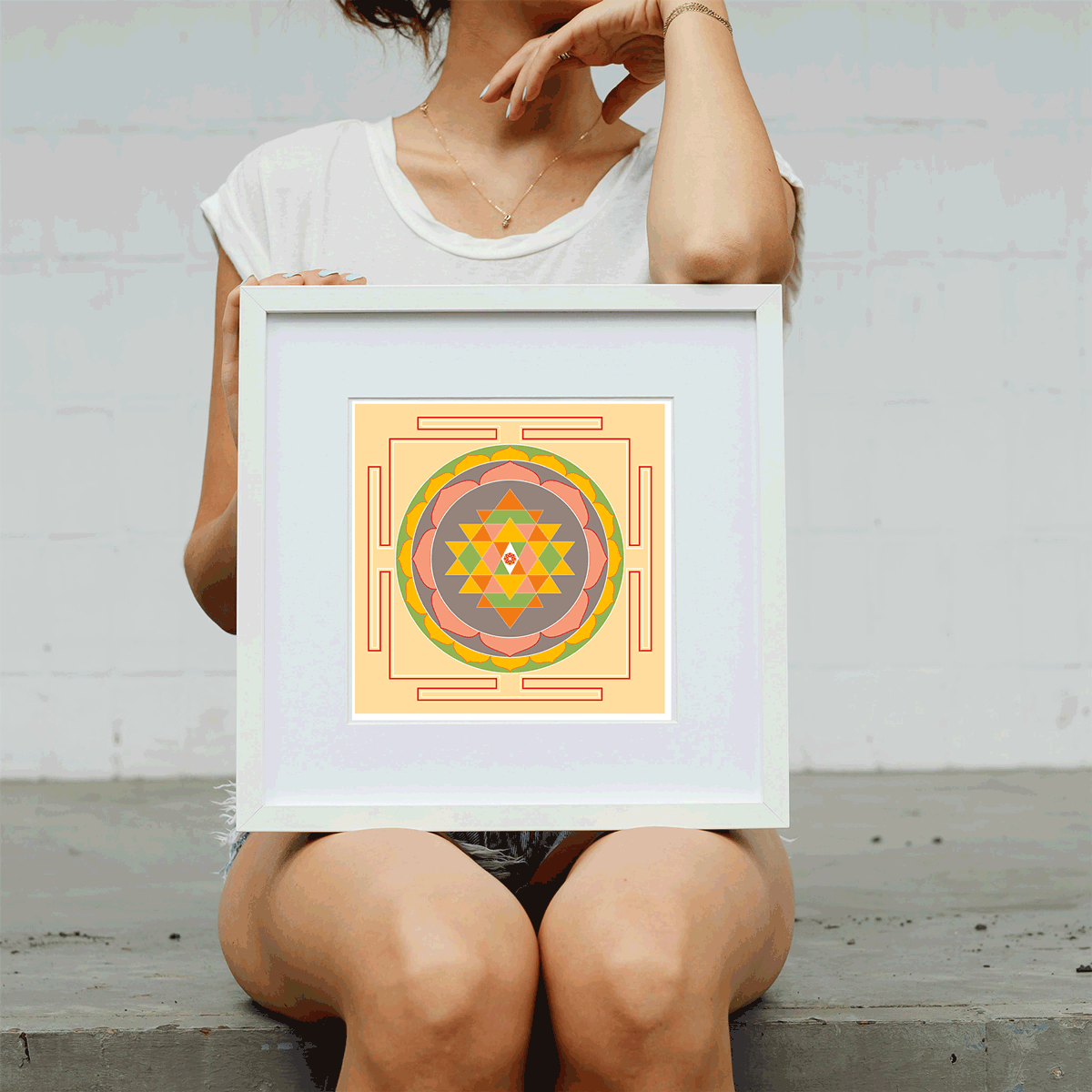 Person holding a framed geometric art print against a plain background