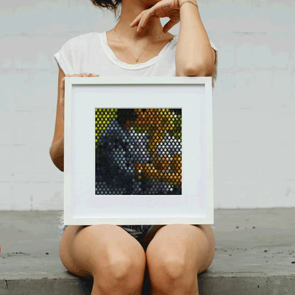 Person holding a framed mosaic art piece with geometric pattern