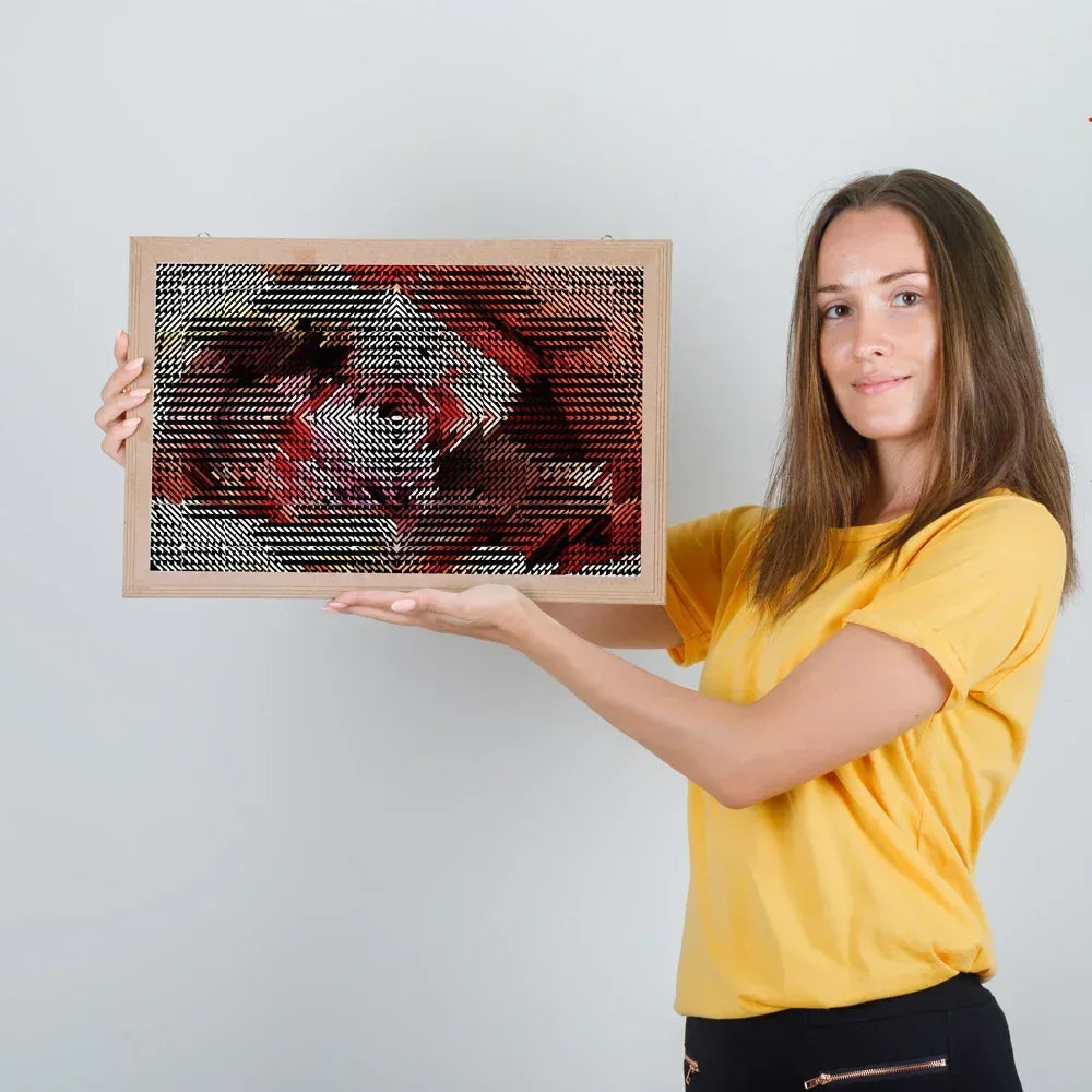 Woman holding a framed artwork against a plain background