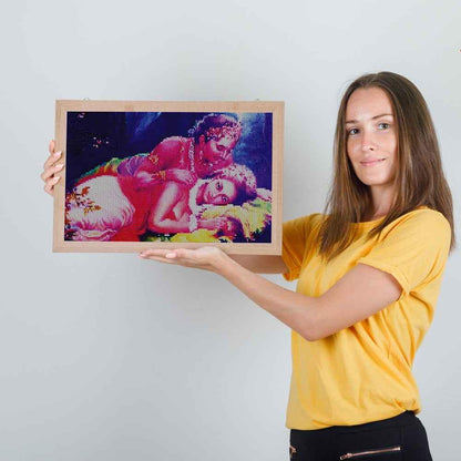 Woman holding a colorful framed artwork against a plain background